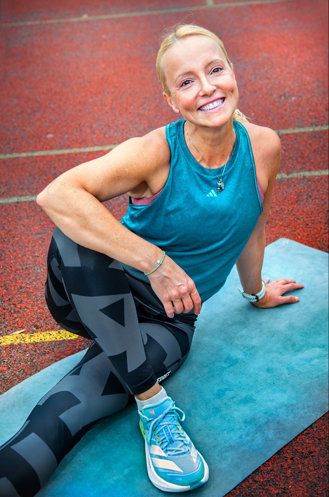 Foto einer Athletin auf Yogamatte in Beindehnung für: Lerne Athleten kompetent mit Yoga zu begleiten: 20 UE Teacher Training mit Biomechanik, Faszientraining & sportartspezifischen Sequenzen.
