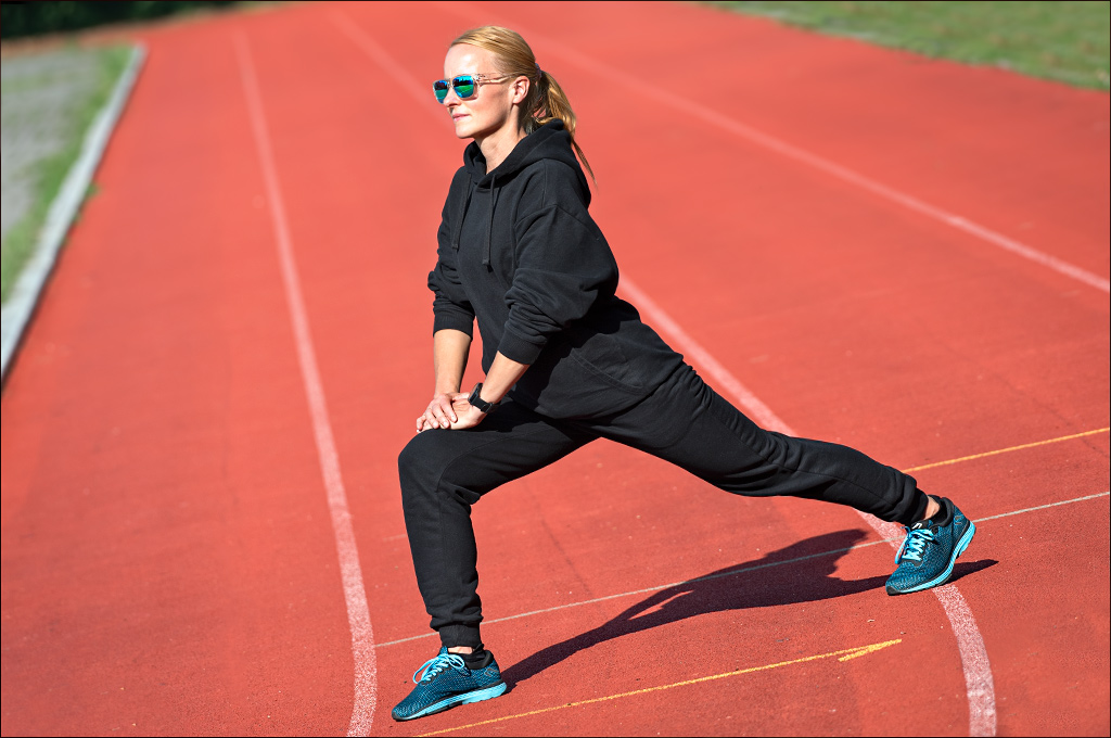 Läuferin macht Yoga Dehnung nach dem Lauftraining zur Regeneration